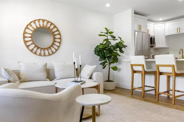 a living room with furniture a mirror and a chandelier