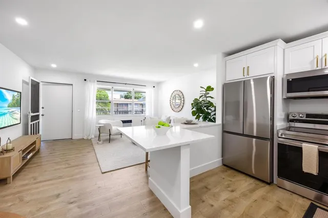 a kitchen with stainless steel appliances a refrigerator sink and microwave
