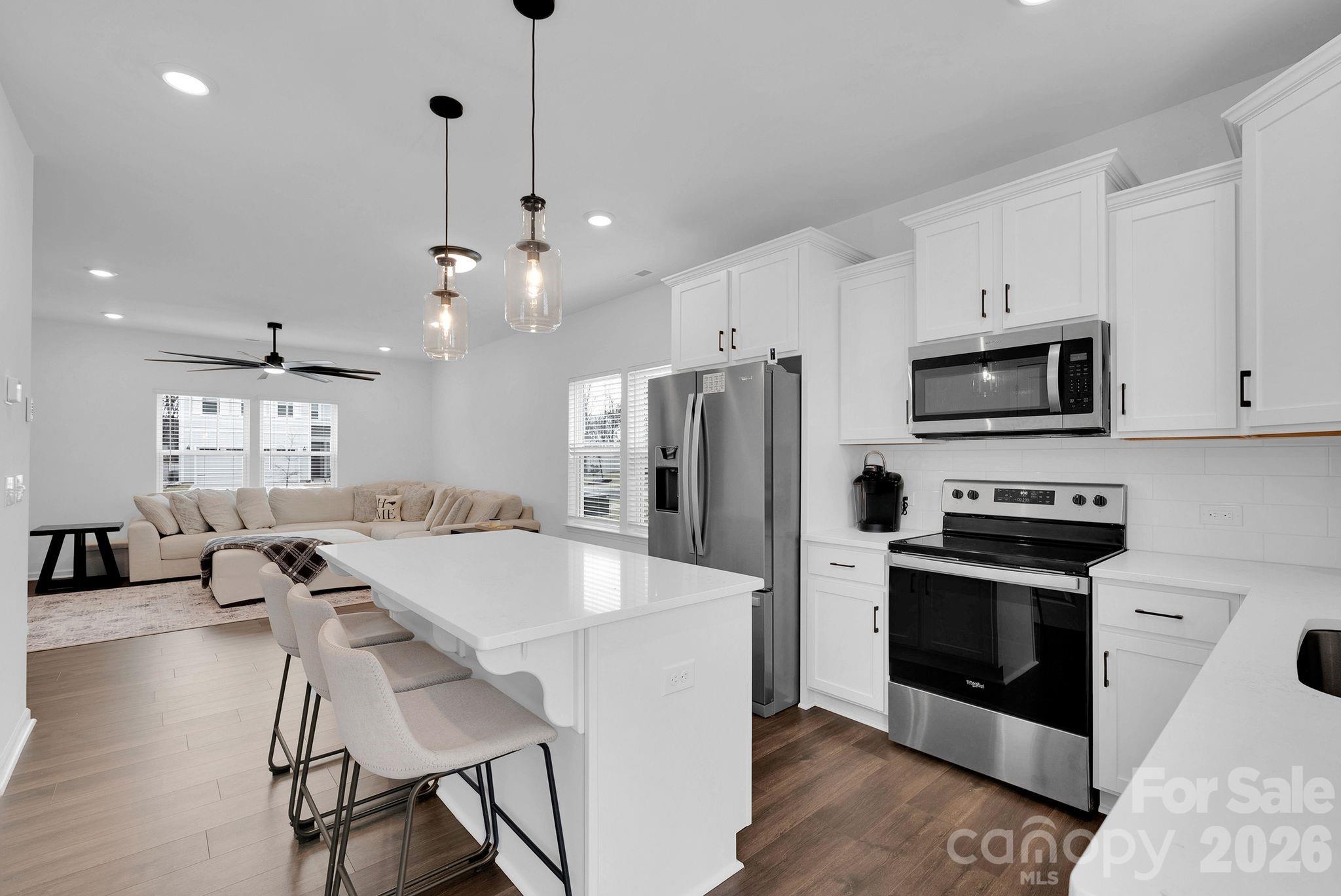 175 Aspire Circle Wingate, NC 28174 - Photo 3 of 24 a kitchen with stainless steel appliances a stove a sink a microwave a refrigerator a stove a dining table and chairs