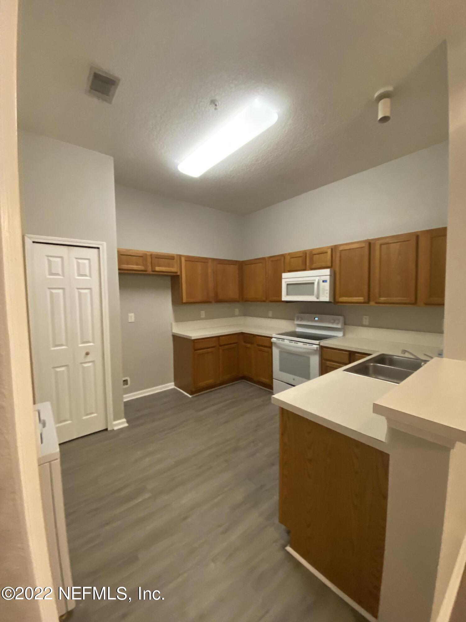 7920 Merrill Road, Unit 101 Jacksonville, FL 32277 - Photo 3 of 14 a kitchen with stainless steel appliances a refrigerator and a stove