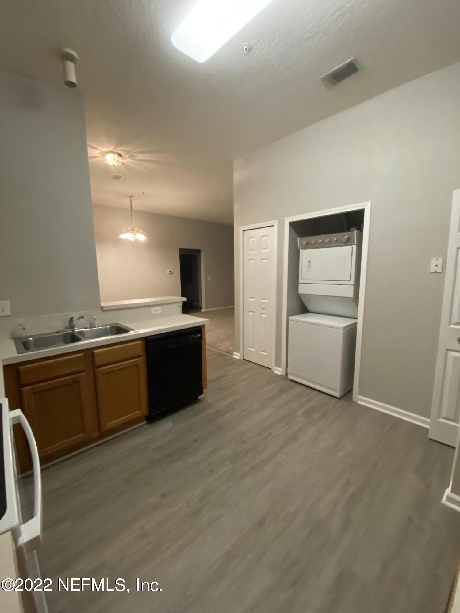 7920 Merrill Road, Unit 101 Jacksonville, FL 32277 - Photo 5 of 14 a large white kitchen with a sink and dishwasher