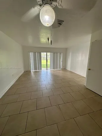 a view of a room with a sink and chandelier fan