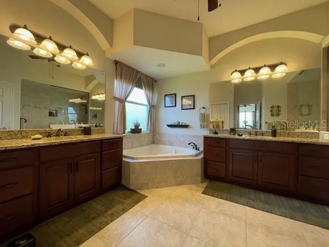 a spacious bathroom with a tub sink and mirror