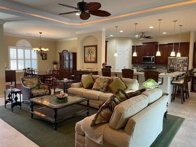 a living room with furniture kitchen view and a large window