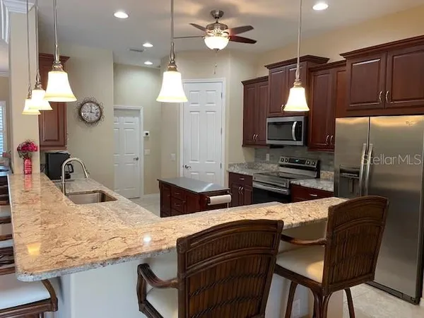 a kitchen with stainless steel appliances granite countertop a sink refrigerator and microwave