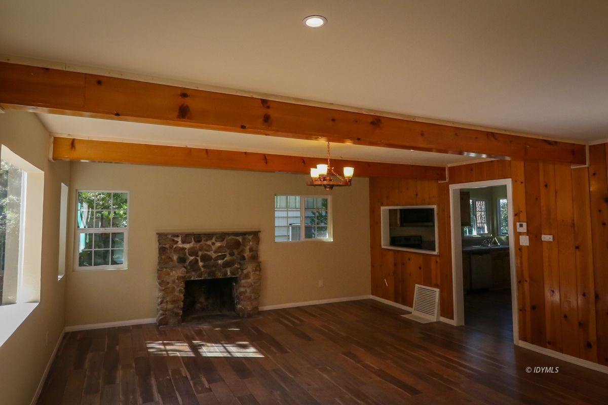 25585 Seneca Road Idyllwild, CA 92549 - Photo 2 of 24 a view of an empty room with wooden floor fireplace and a window