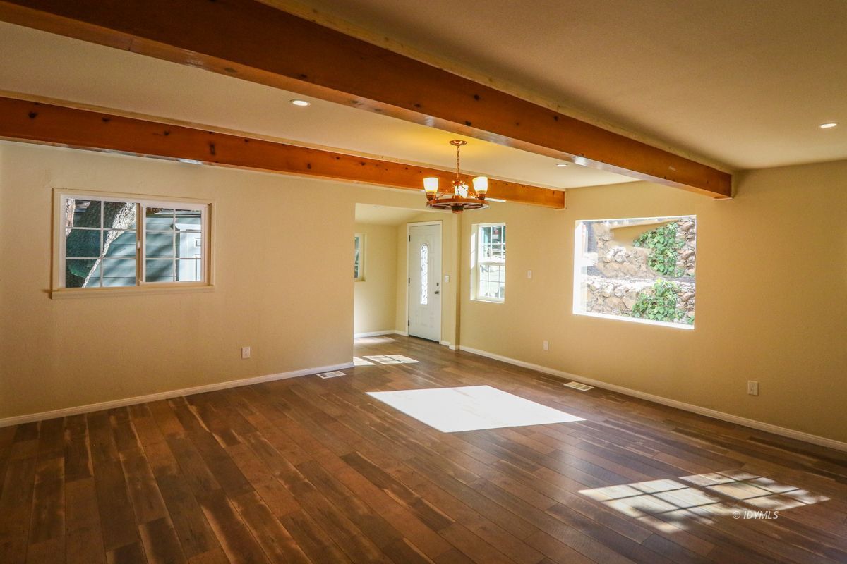 25585 Seneca Road Idyllwild, CA 92549 - Photo 3 of 24 a view of an empty room with wooden floor and a window