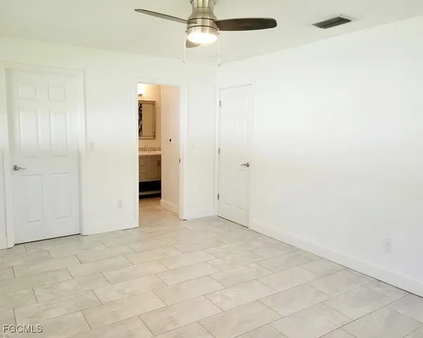 an empty room with a ceiling fan and carpet