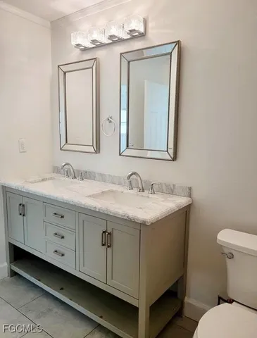 a bathroom with a granite countertop toilet a sink and a mirror