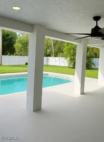 a view of an empty room with a window and a swimming pool