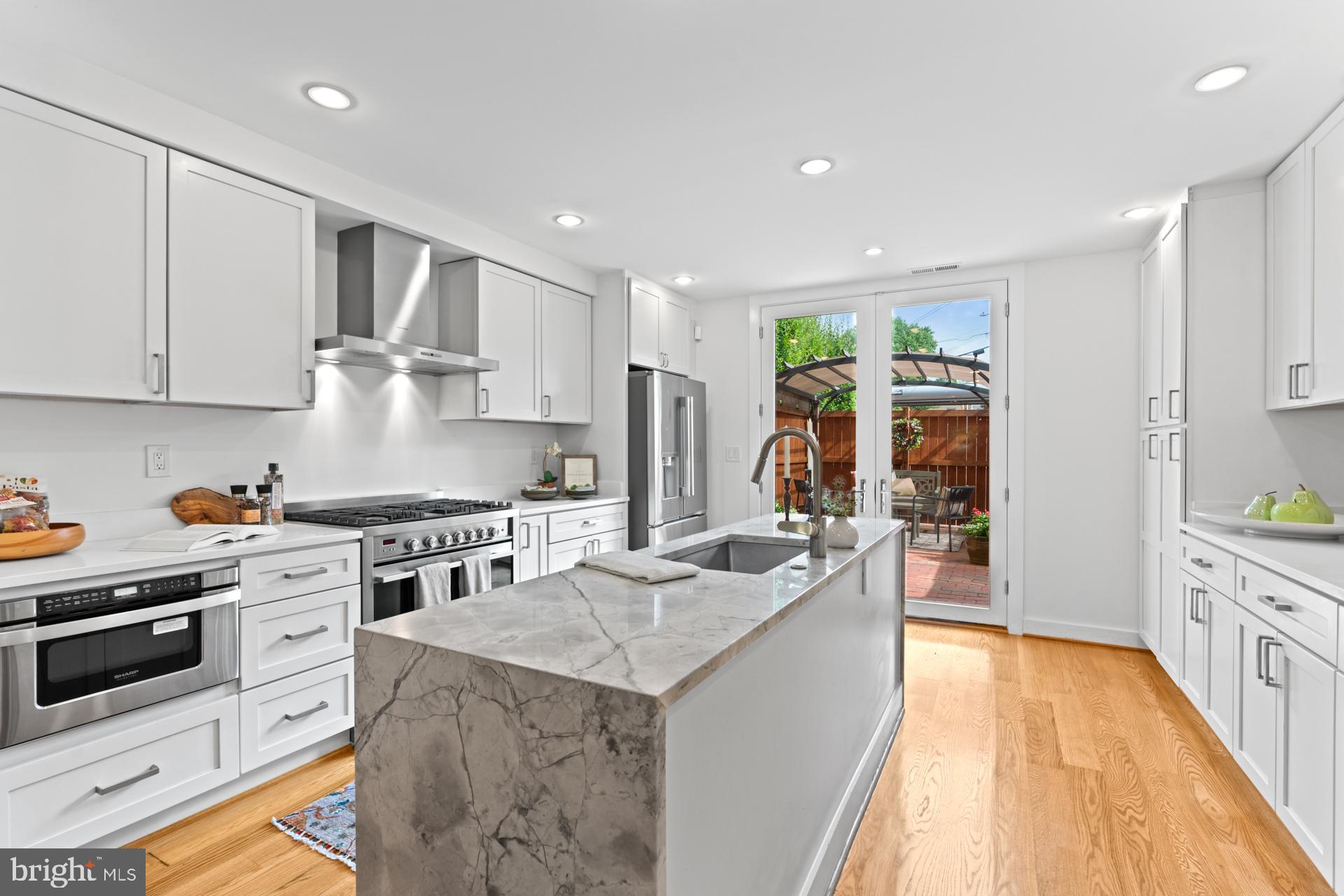 320 A Street Northeast Washington, DC 20002 - Photo 2 of 36 a kitchen with stainless steel appliances granite countertop a stove top oven a sink dishwasher and a refrigerator with wooden floor