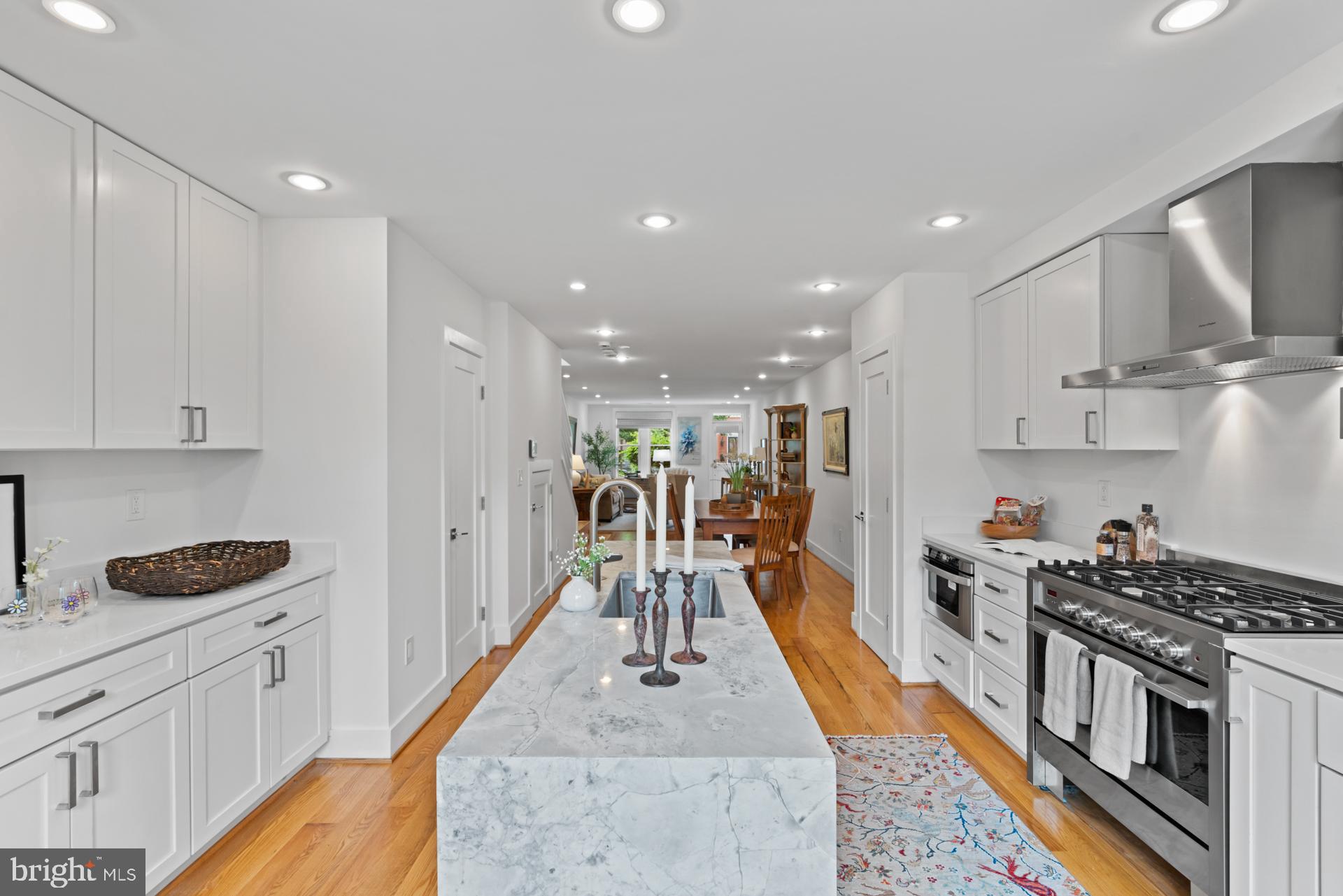 320 A Street Northeast Washington, DC 20002 - Photo 4 of 36 a kitchen with stainless steel appliances kitchen island granite countertop a stove a sink a refrigerator and white cabinets with wooden floor