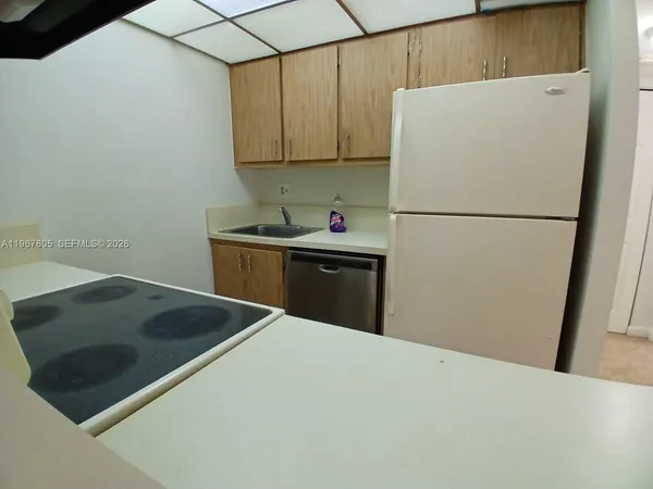 a kitchen with a sink a refrigerator and cabinets