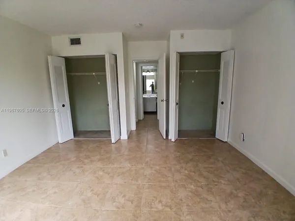 an empty room with closet and a bathroom