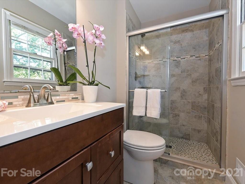 6918 Windyrush Road Charlotte, NC 28226 - Photo 14 of 26 a bathroom with a sink a toilet a mirror and shower