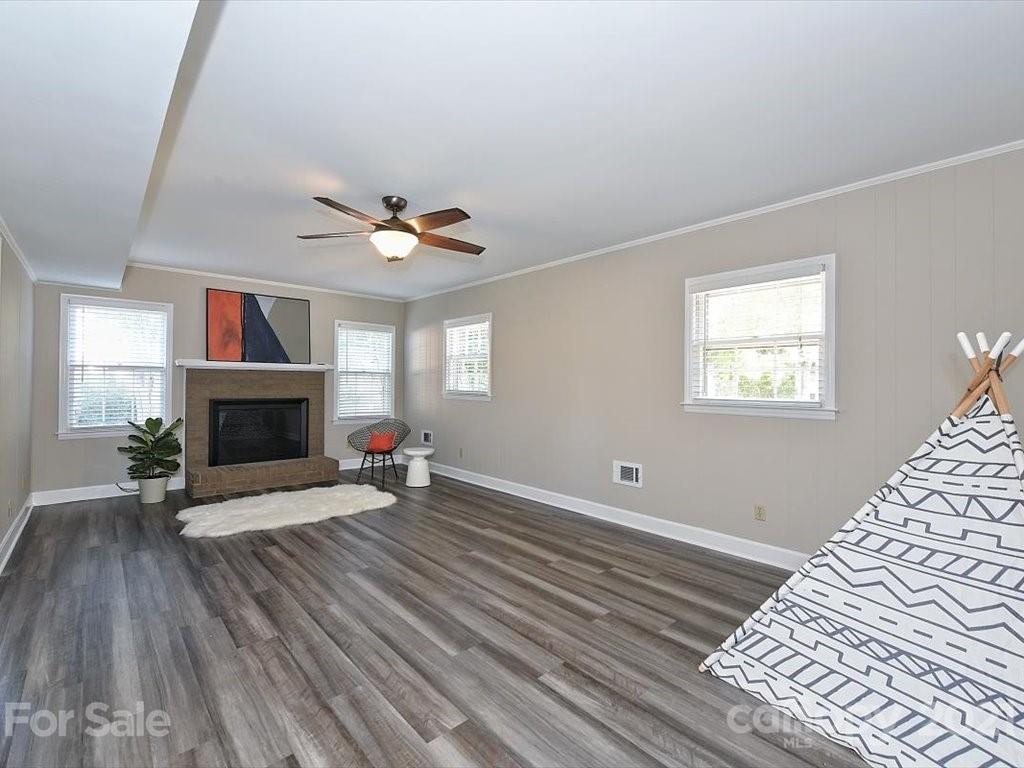 6918 Windyrush Road Charlotte, NC 28226 - Photo 18 of 26 a view of an empty room with wooden floor fireplace and a window