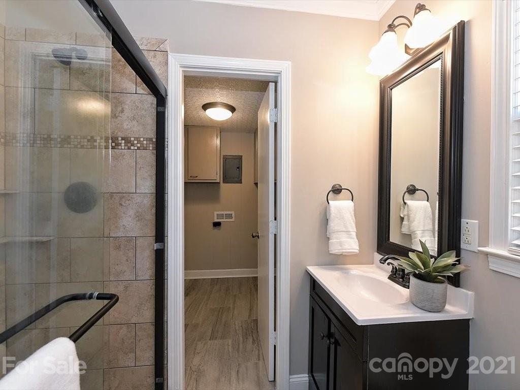 6918 Windyrush Road Charlotte, NC 28226 - Photo 20 of 26 a bathroom with a sink a mirror and a shower