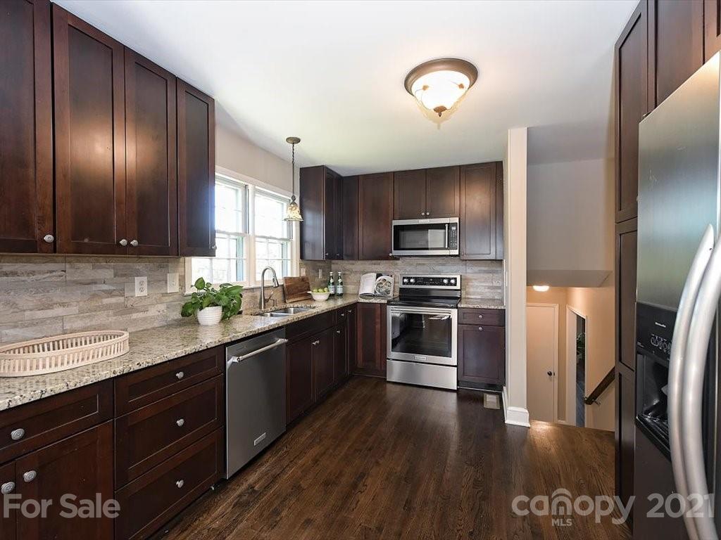 6918 Windyrush Road Charlotte, NC 28226 - Photo 9 of 26 a kitchen with granite countertop stainless steel appliances and wooden cabinets