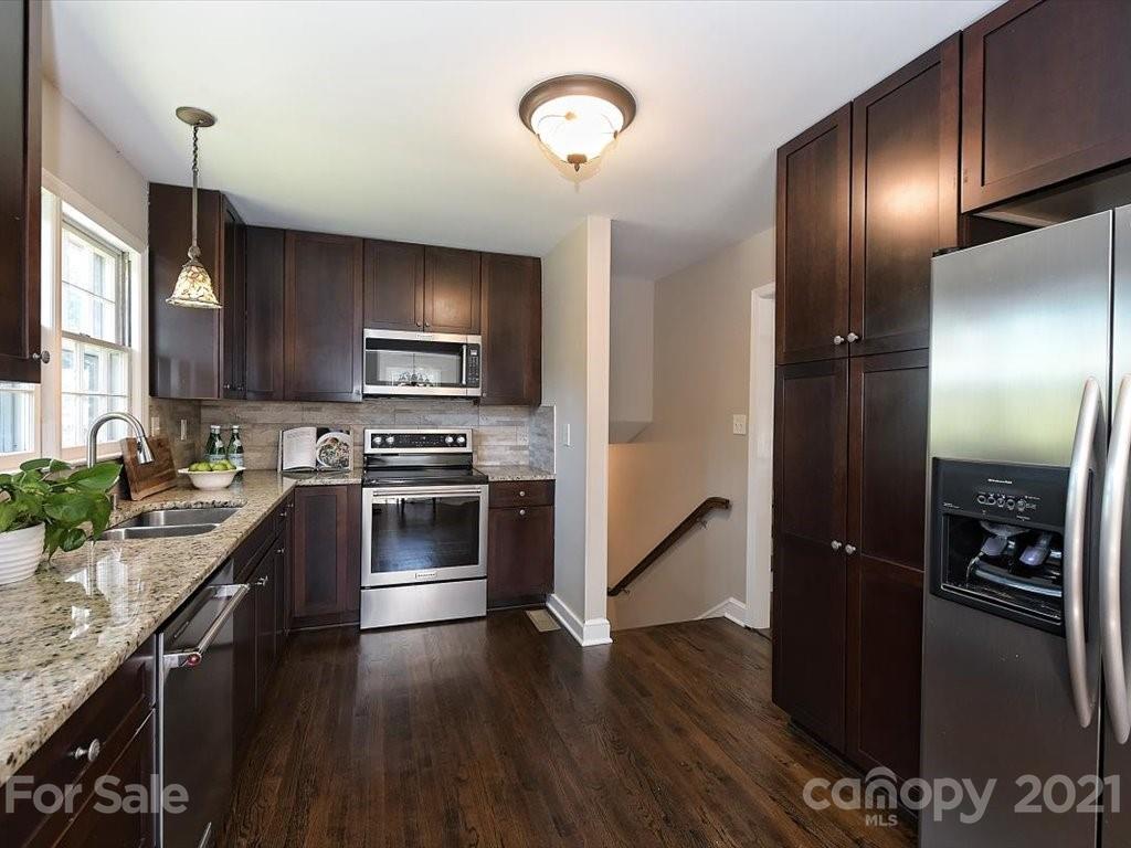 6918 Windyrush Road Charlotte, NC 28226 - Photo 10 of 26 a kitchen with granite countertop stainless steel appliances and wooden cabinets