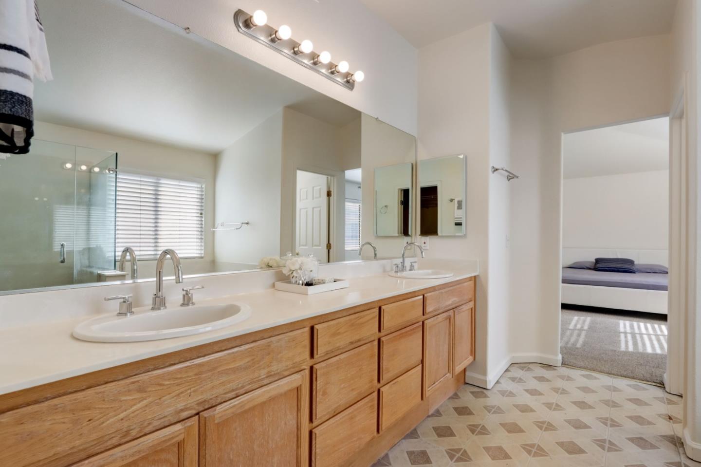 8911 Del Rio Circle Gilroy, CA 95020 - Photo 14 of 29 a bathroom with double vanity sinks and a mirror