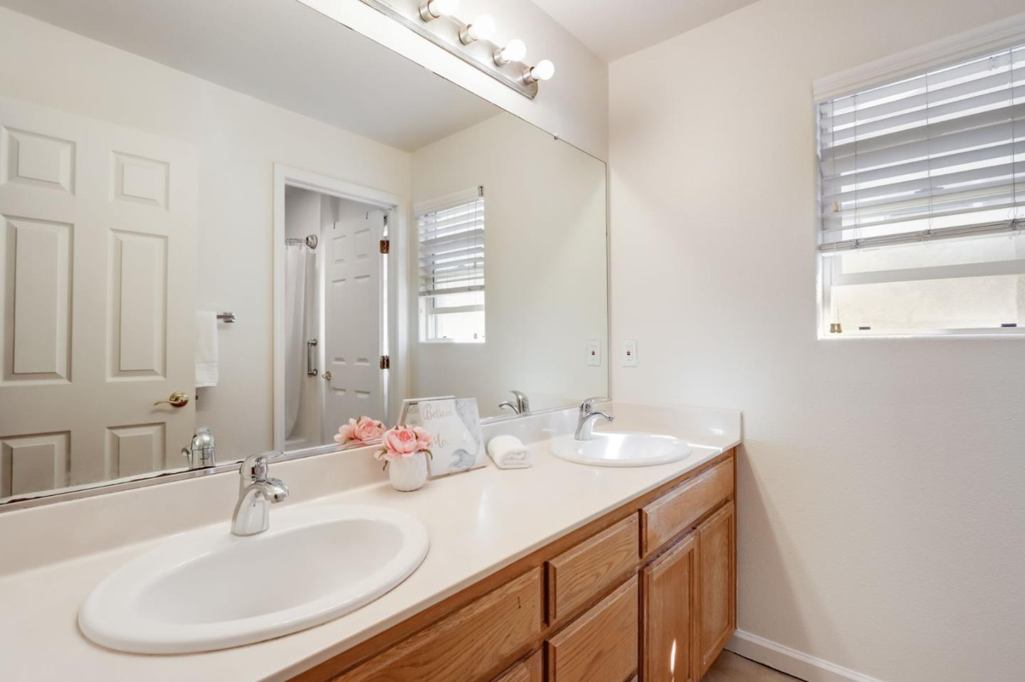8911 Del Rio Circle Gilroy, CA 95020 - Photo 19 of 29 a bathroom with double vanity sinks and a mirror