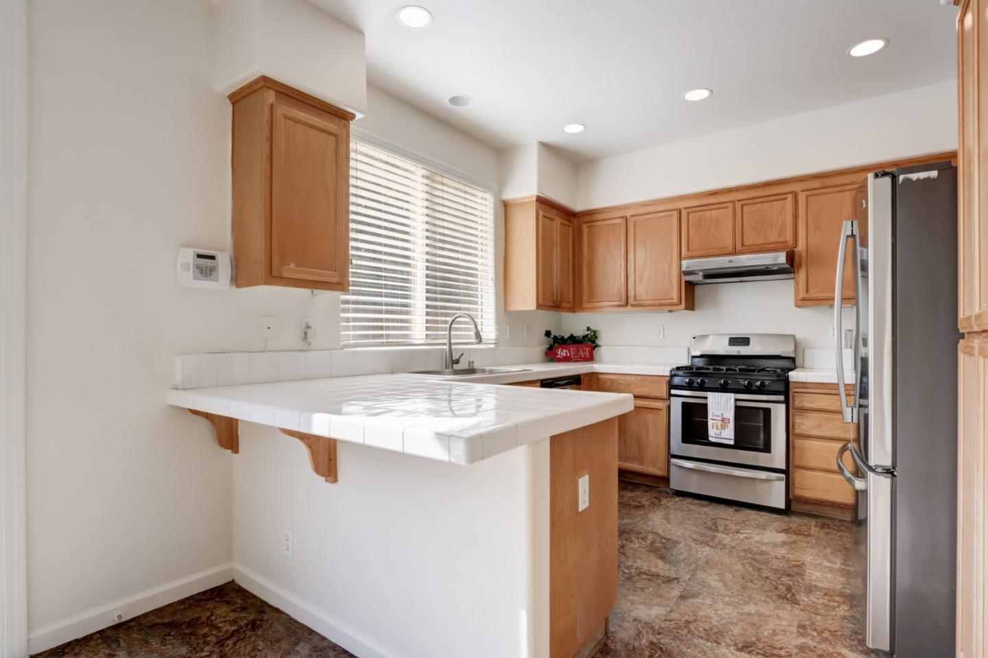 8911 Del Rio Circle Gilroy, CA 95020 - Photo 7 of 29 a kitchen with stainless steel appliances granite countertop a sink stove and refrigerator