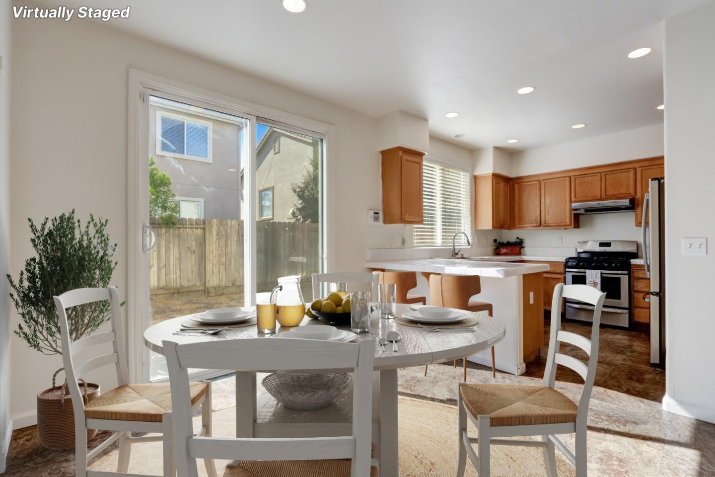 8911 Del Rio Circle Gilroy, CA 95020 - Photo 10 of 29 a kitchen with a table chairs refrigerator and cabinets