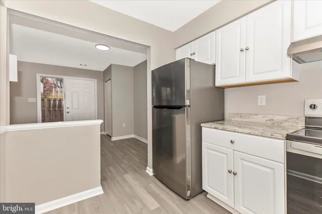 a kitchen with stainless steel appliances granite countertop a refrigerator and a stove