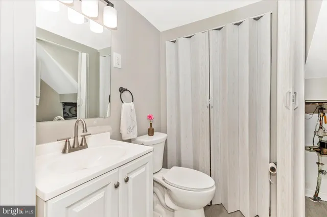 a bathroom with a sink vanity mirror and toilet