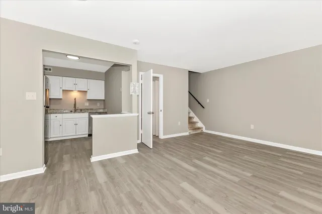 a view of a kitchen with wooden floor and a sink