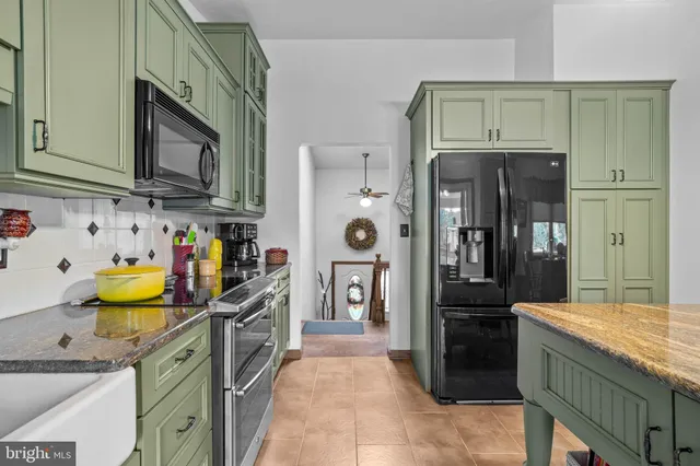 a kitchen with stainless steel appliances granite countertop a refrigerator and a stove top oven
