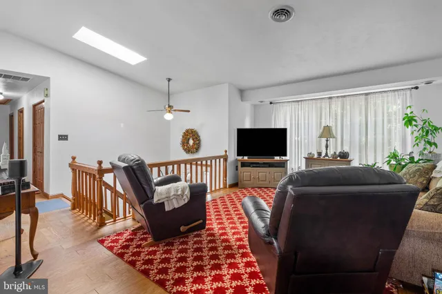 a living room with furniture a flat screen tv and a table