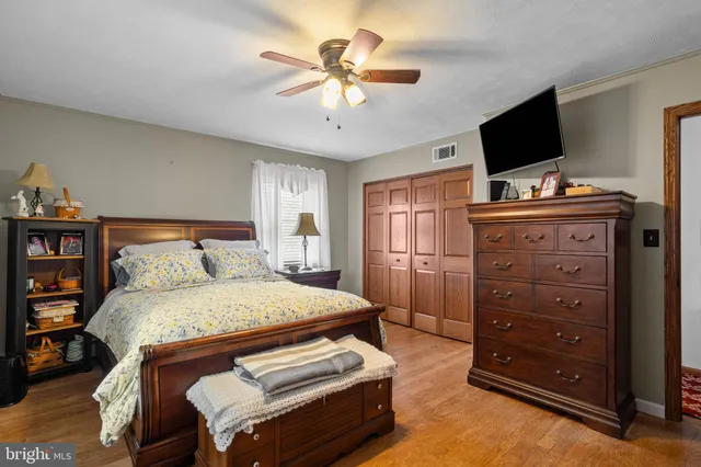 a bedroom with a bed and a flat tv screen on dresser