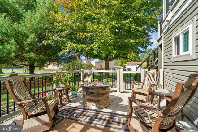 a view of a patio with table and chairs and potted plants with wooden floor and fence