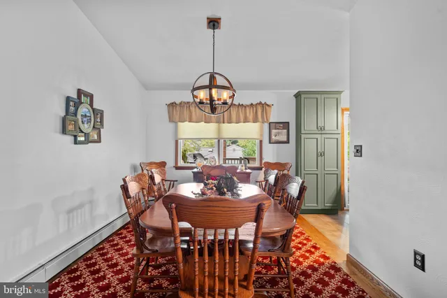 a dining room with furniture a chandelier and wooden floor