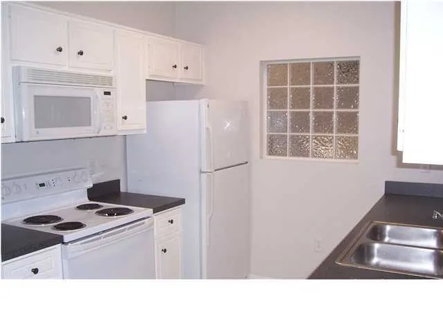a kitchen with white cabinets and white appliances
