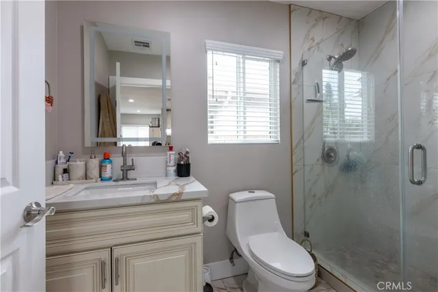 a bathroom with a sink toilet vanity and shower