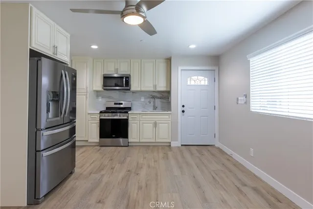 a kitchen with a refrigerator and a stove top oven
