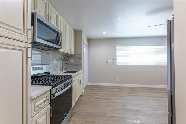 a kitchen with stainless steel appliances a stove a microwave and white cabinets