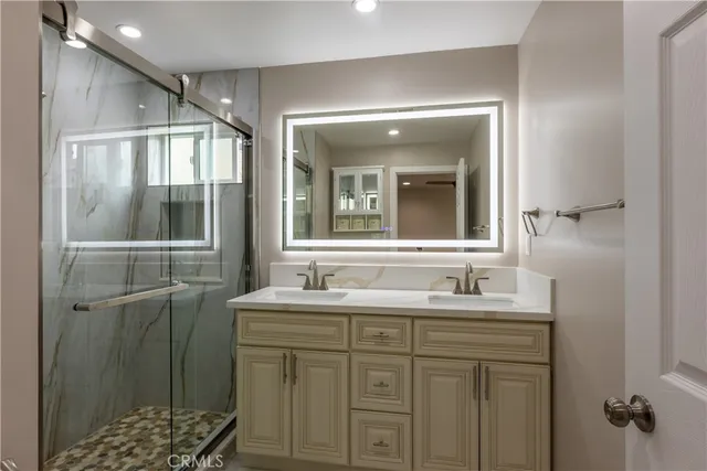 a bathroom with a sink a mirror and a shower