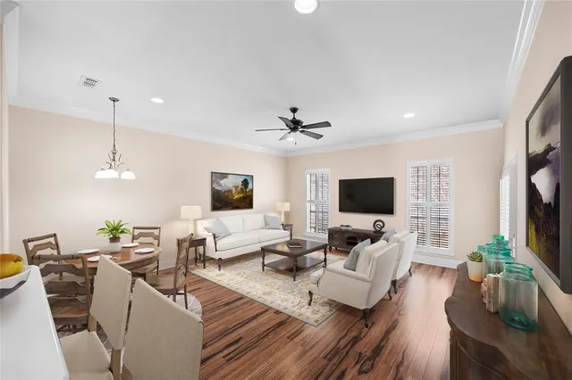 a living room with furniture flat screen tv and wooden floor