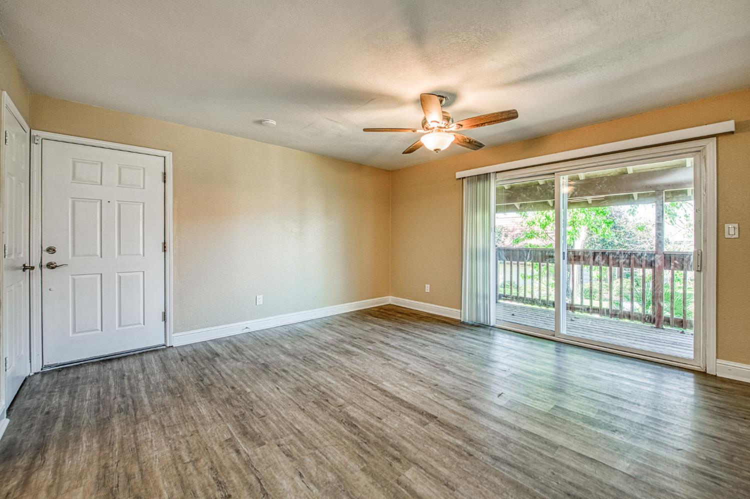 2881 Huntington Boulevard, Unit 262 Fresno, CA 93721 - Photo 12 of 31 a view of an empty room with a window and wooden floor