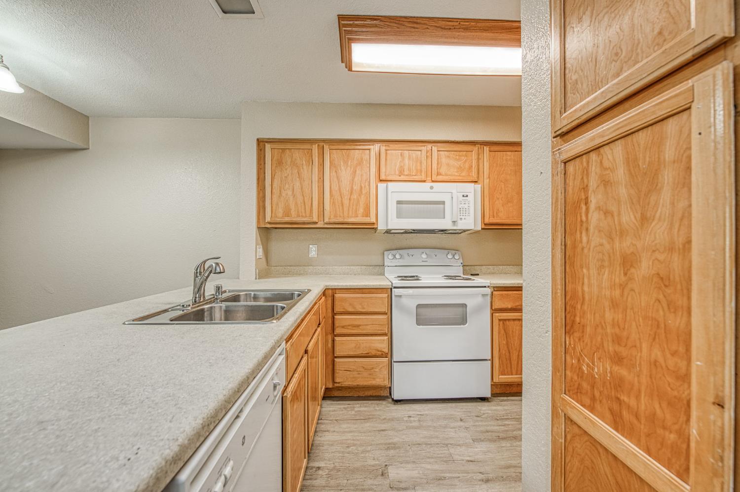 2881 Huntington Boulevard, Unit 262 Fresno, CA 93721 - Photo 16 of 31 a kitchen with a stove a sink and a window