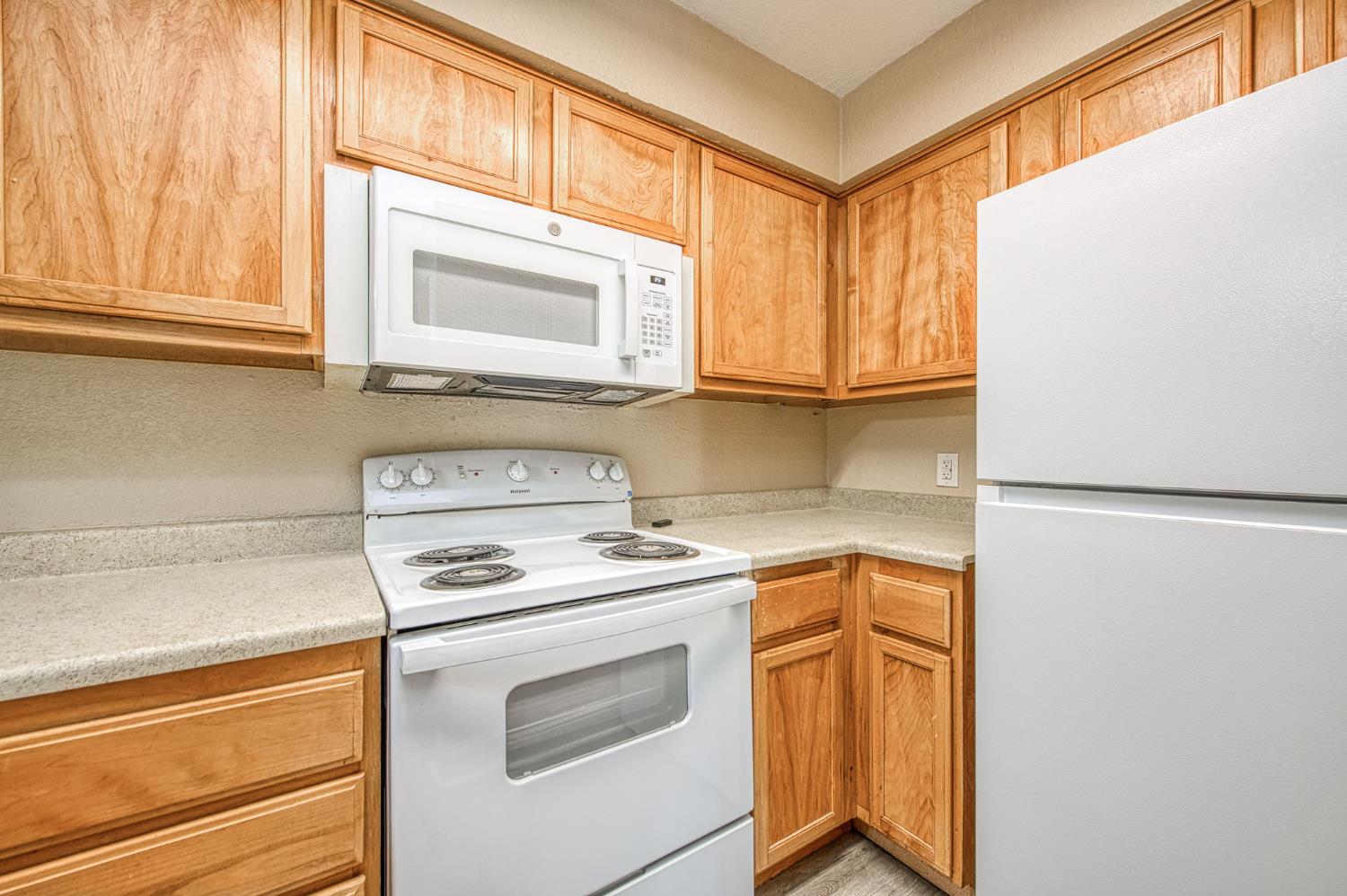 2881 Huntington Boulevard, Unit 262 Fresno, CA 93721 - Photo 17 of 31 a kitchen with a stove microwave and cabinets