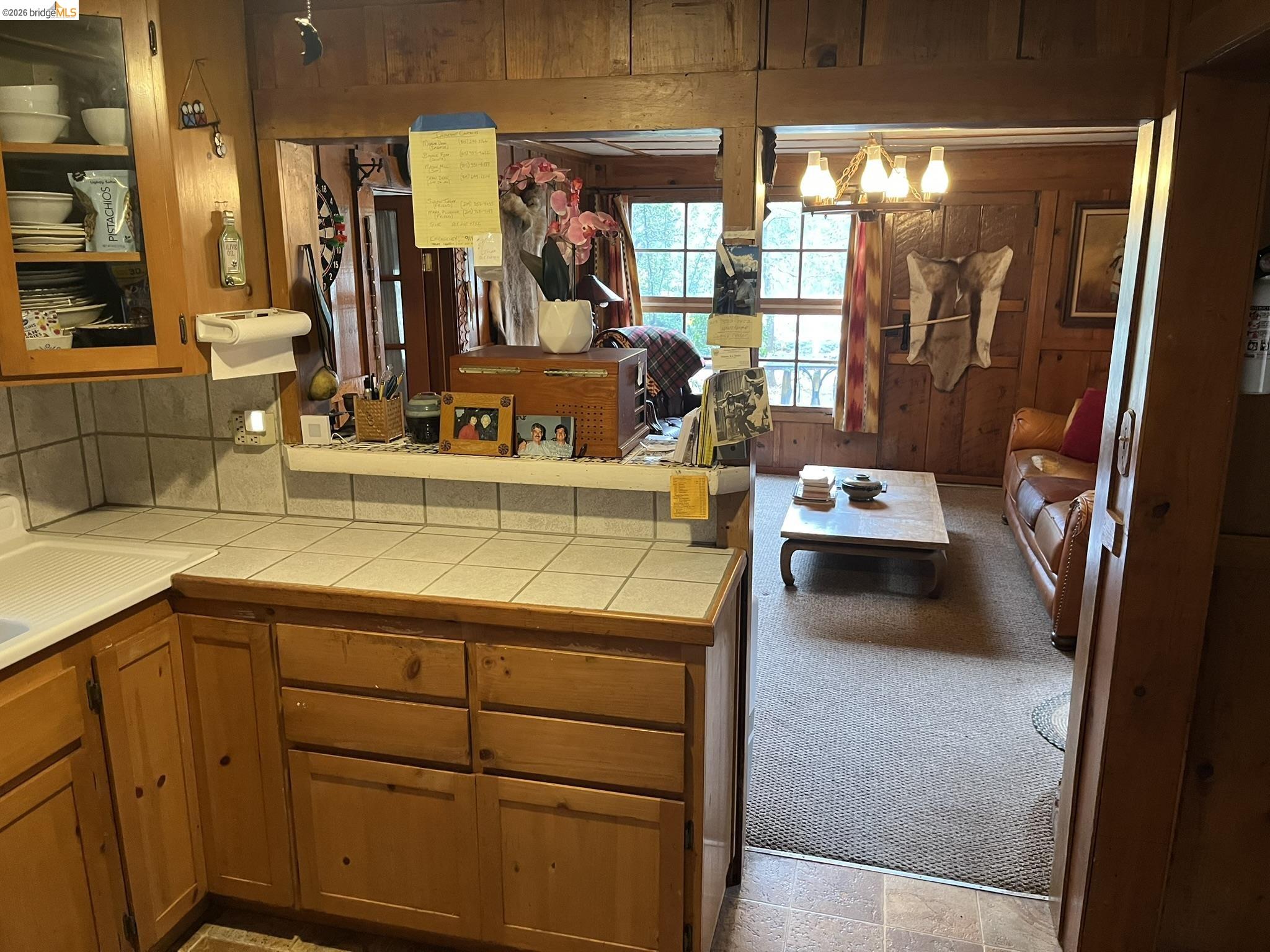 23090 North Bald Mountain Road Sonora, CA 95370 - Photo 11 of 59 Kitchen featuring tile counters, wood finish cabinetry, and wooden walls