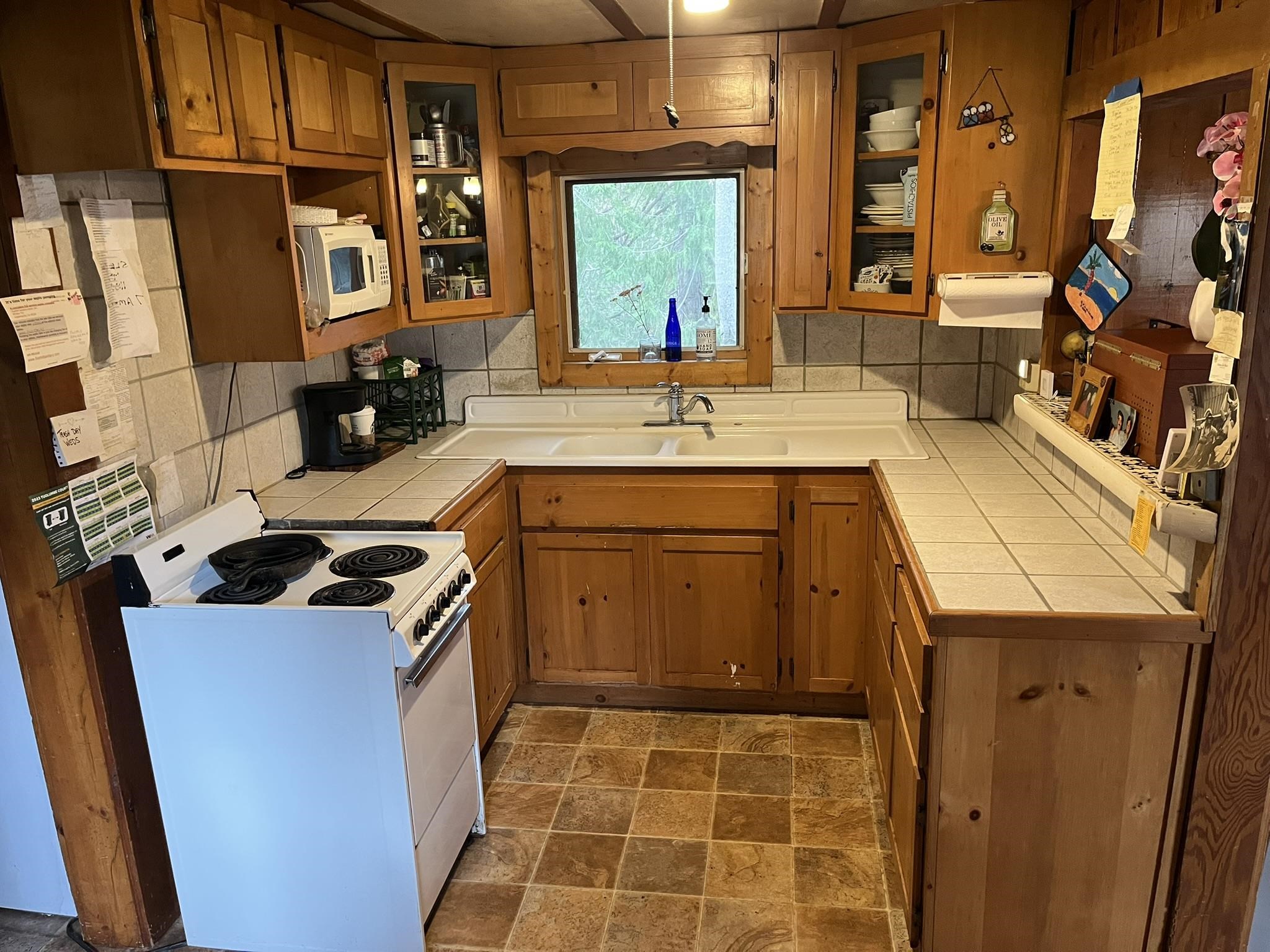 23090 North Bald Mountain Road Sonora, CA 95370 - Photo 12 of 59 Kitchen with white appliances, stone finish flooring, tile countertops, and wood finish cabinets