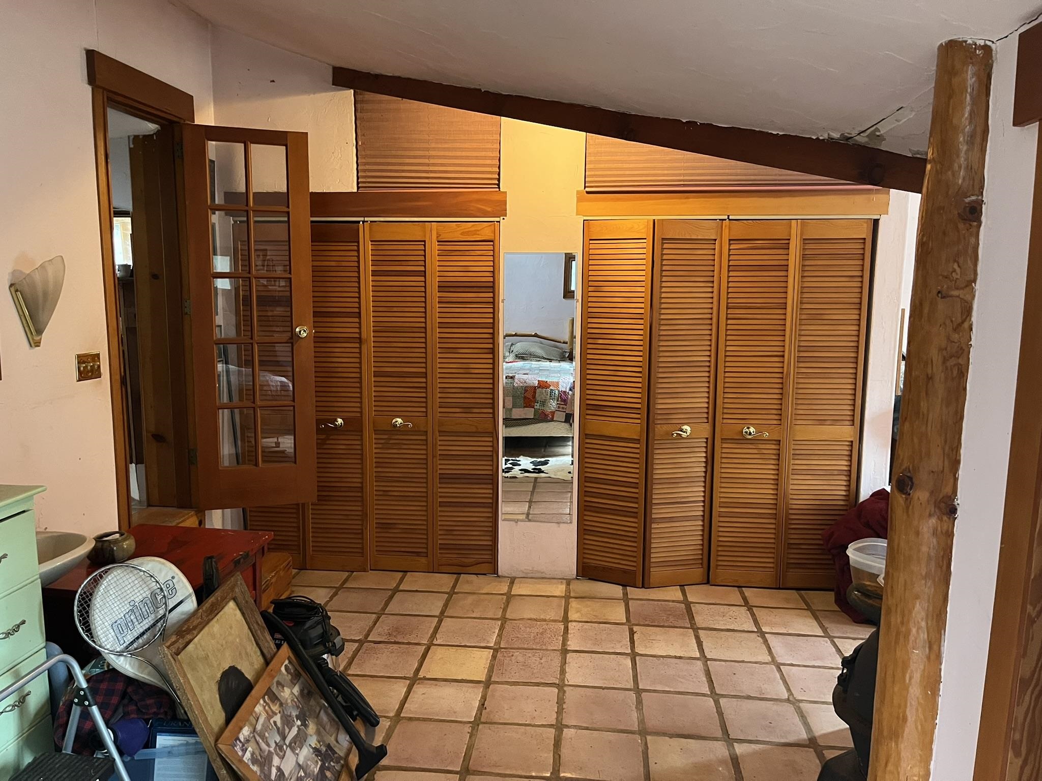 23090 North Bald Mountain Road Sonora, CA 95370 - Photo 20 of 59 Unfurnished bedroom featuring multiple closets, stone tile floors, and vaulted ceiling