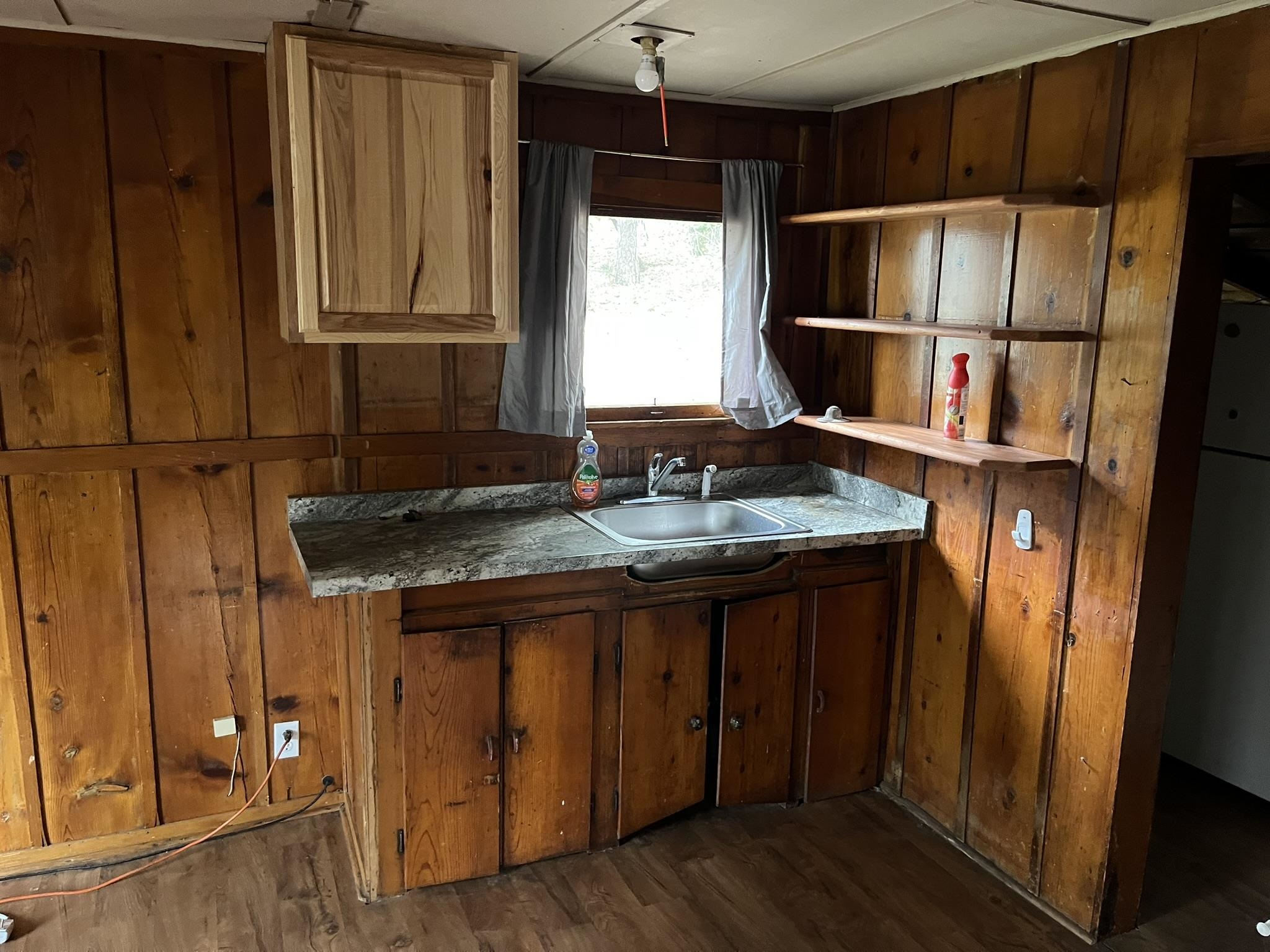 23090 North Bald Mountain Road Sonora, CA 95370 - Photo 30 of 59 Kitchen featuring freestanding refrigerator, dark wood-style flooring, and wooden walls