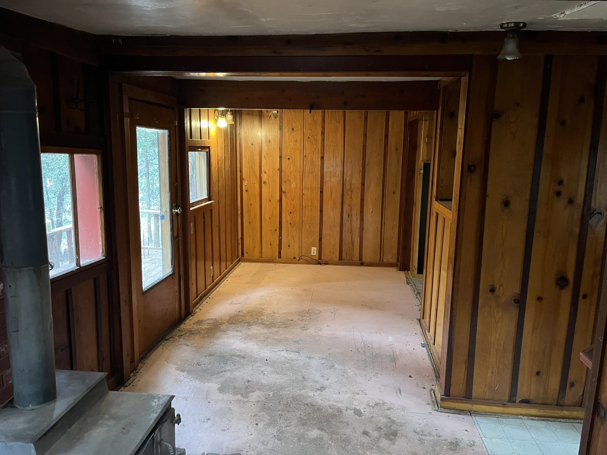 23090 North Bald Mountain Road Sonora, CA 95370 - Photo 36 of 59 Interior space featuring a wood stove and wooden walls