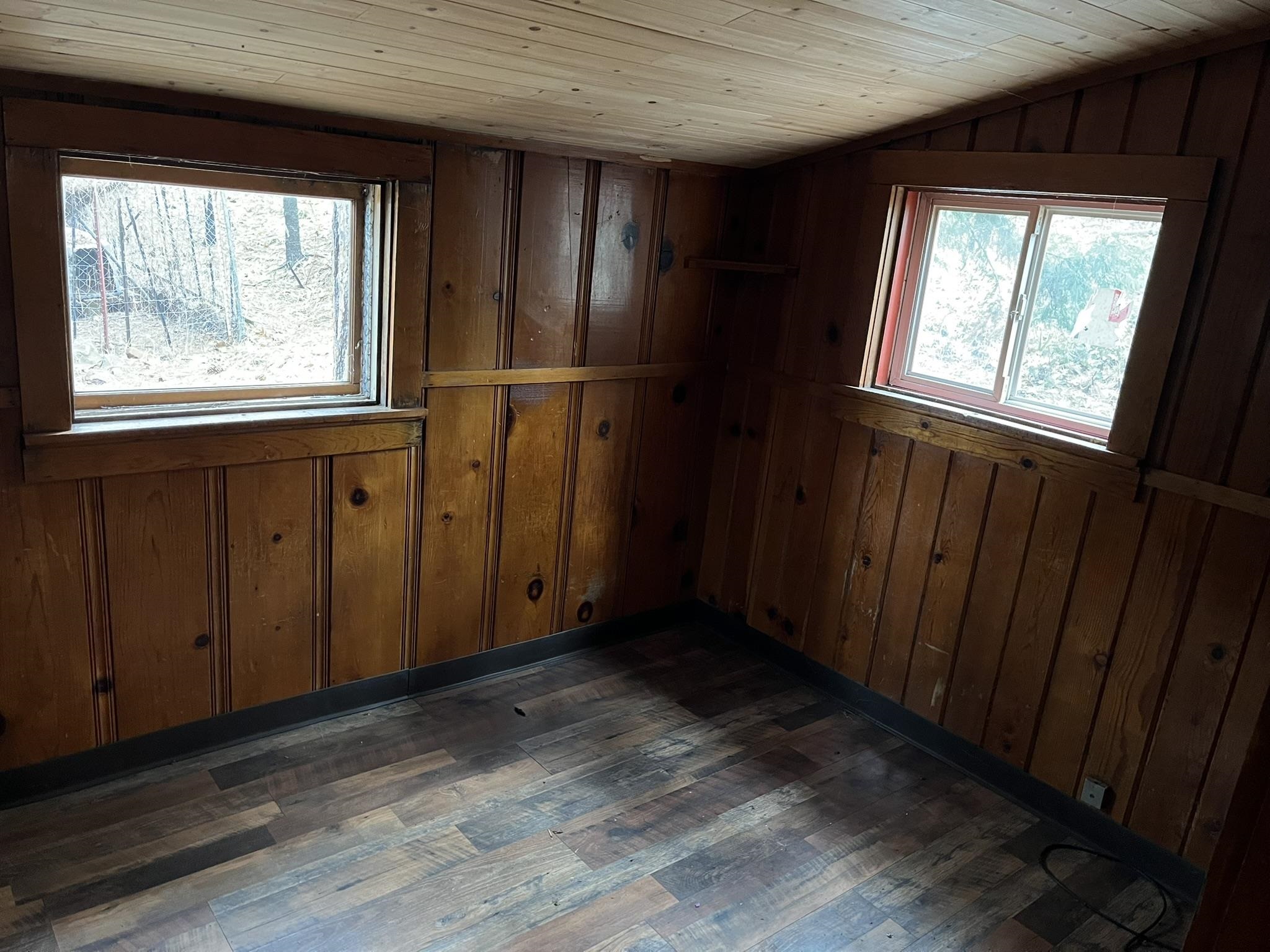23090 North Bald Mountain Road Sonora, CA 95370 - Photo 44 of 59 Spare room featuring dark wood-style floors, wood walls, a vaulted wood ceiling, and healthy amount of natural light